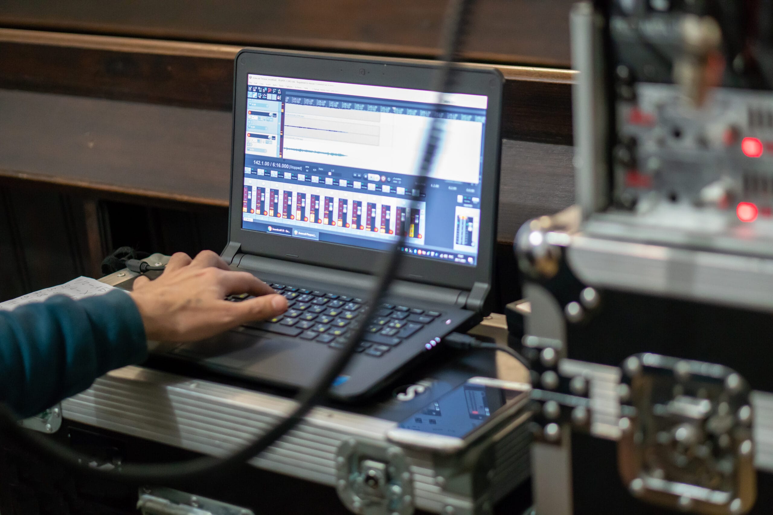 A sound engineer with headphones sits in front of a laptop while recording or listening. Male sound engineer in a recording studio